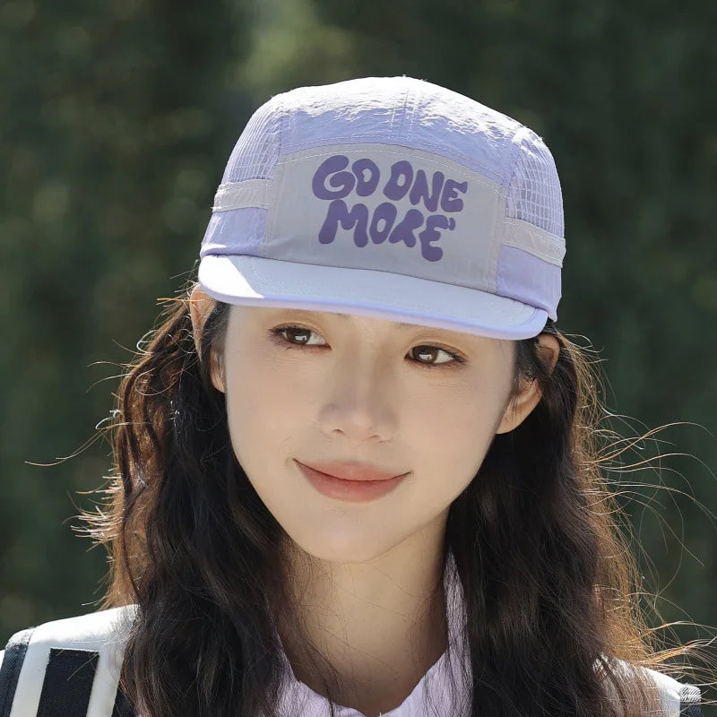A woman wearing a light purple breathable quick-dry baseball cap with the text GOD ONE MORE on the front.