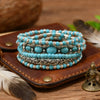 Une pile de cinq bracelets de perles turquoise bohèmes sur une carte en cuir marron avec une plume.