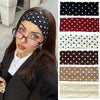 Eine Frau präsentiert Haarbänder mit Polka Dots in Schwarz, Rot, Weiß, Braun und Beige.