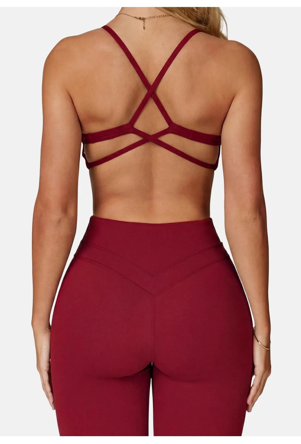 A model wearing a maroon high-support sports bra and matching leggings, shown from the back.