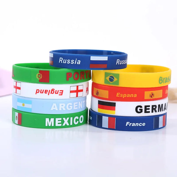 A collection of colorful silicone wristbands featuring various national flags and country names.