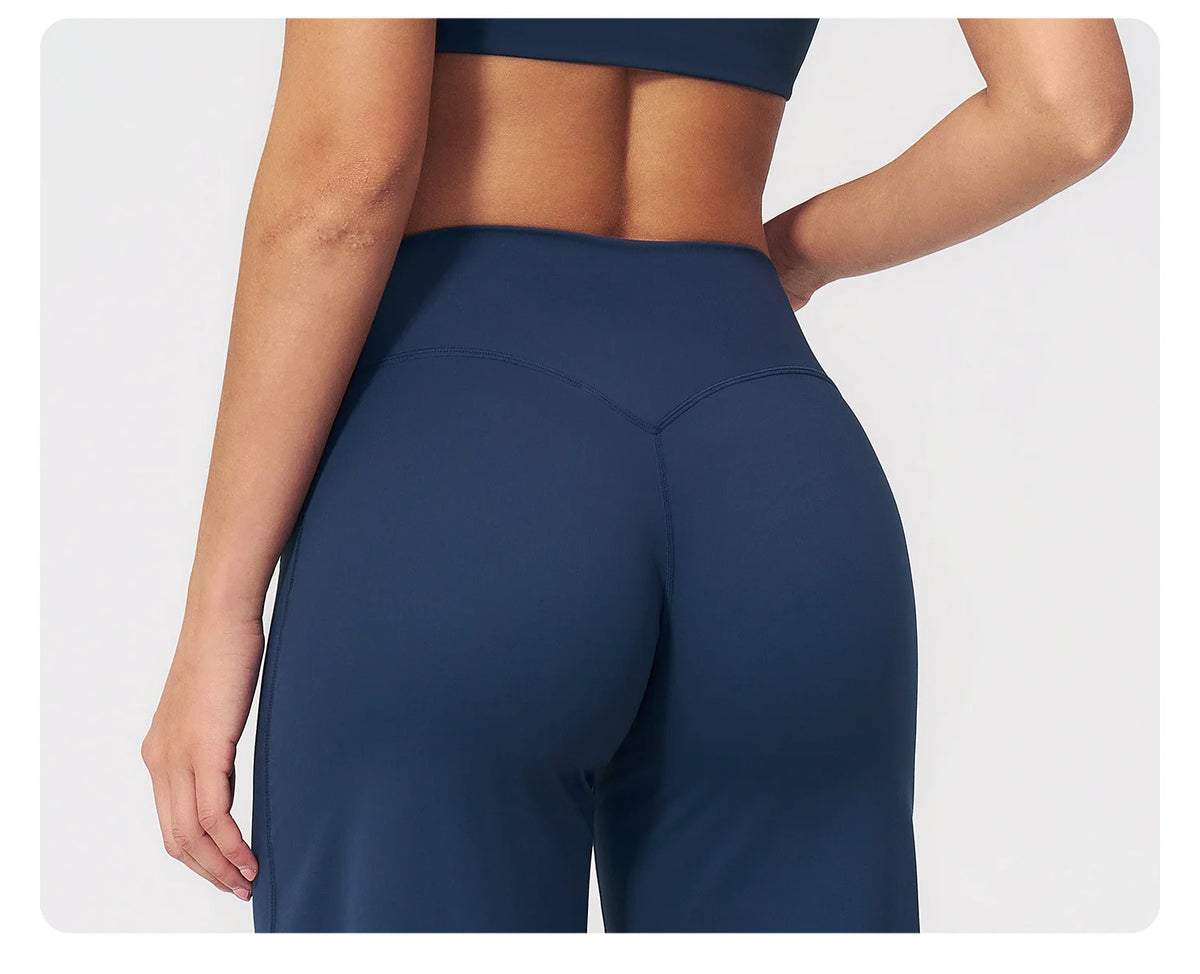 A close-up shot of a woman wearing navy blue high-waist flared yoga pants.