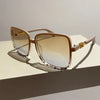 Retro two-tone gradient sunglasses with light brown frames and tinted lenses resting on a white surface.