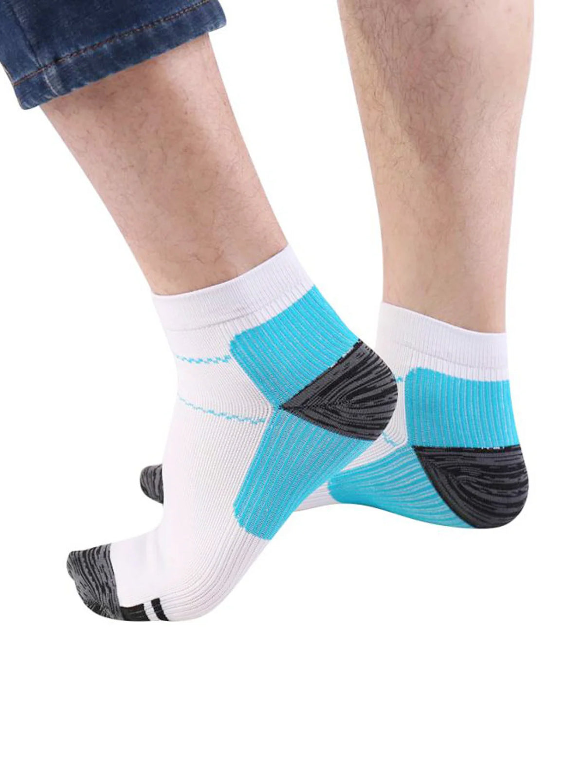 A pair of white and teal compression socks with black accents worn on a person's foot.