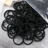 A pile of 50 pieces of mixed color elastic hair bands on a gray surface.