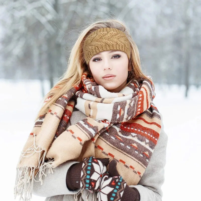 Una mujer usando una diadema de punto beige y una bufanda estampada al aire libre en la nieve.