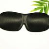 Black memory foam sleep mask with a green leaf in the background