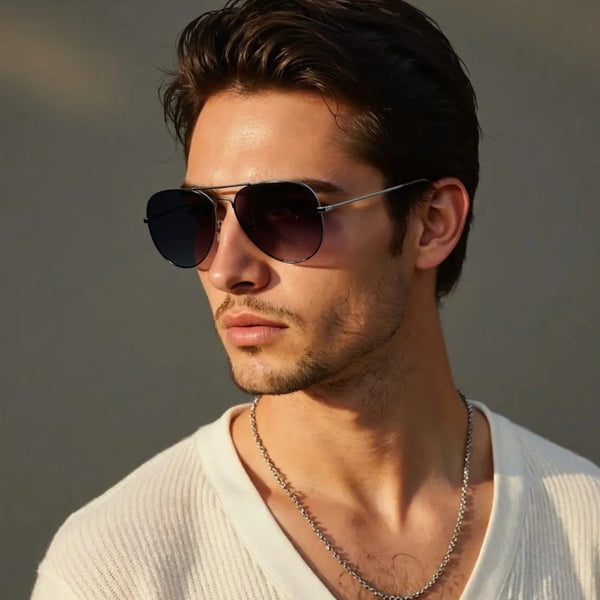 A close-up photo of a man wearing classic polarized pilot sunglasses with a silver frame and dark lenses.