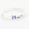 A white silicone wristband with the number 24 and a signature engraved on it.