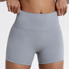 Short de yoga gris clair taille haute et compression portés par une personne.