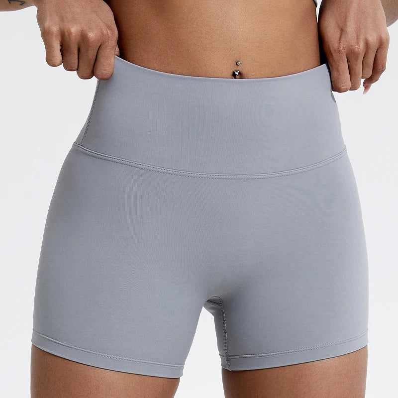 Short de yoga gris clair taille haute et compression portés par une personne.