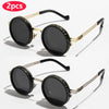 A pair of black round sunglasses with gold-toned metal frames and adjustable dimming.