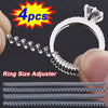 A set of four invisible ring size adjuster tools for resizing rings, shown with a silver ring and adjustment pieces.