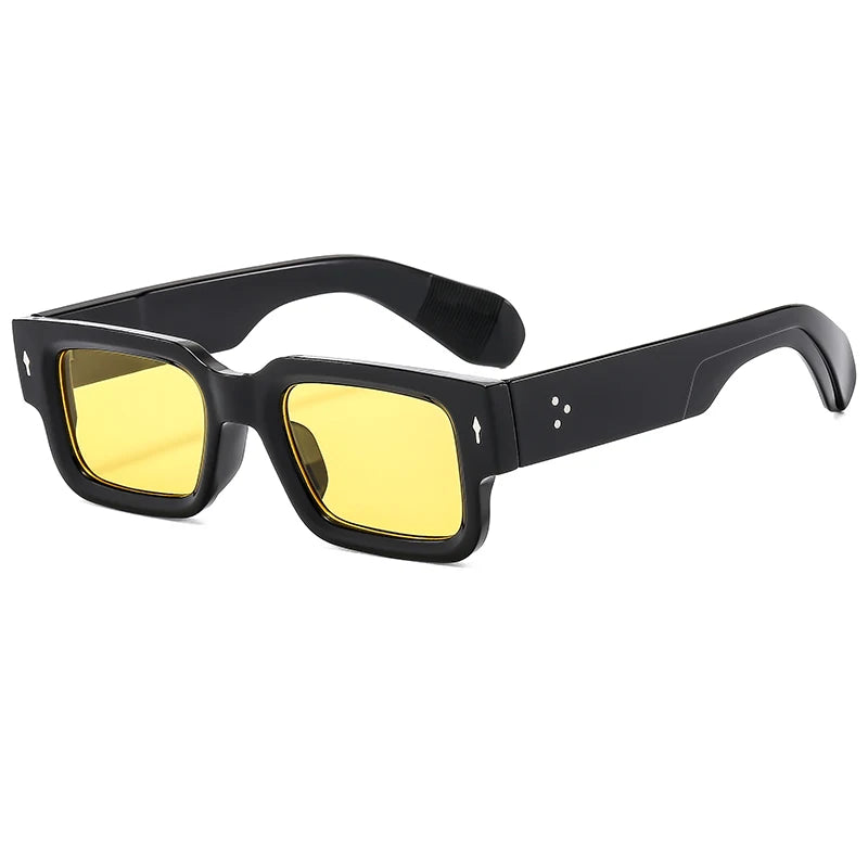 Black square riveted sunglasses with yellow lenses shown from the front.