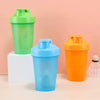 Three plastic sports bottles in green, blue, and orange colors standing on a white block.