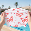 A hand holds a pink butterfly print silicone swimming cap against a bright blue pool background.