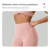 Nahaufnahme einer Frau mit einem hellrosa, eng anliegenden Yoga-Mieder und Leggings.
