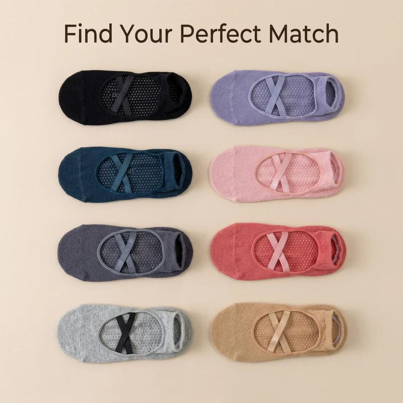 A collection of various colored crisscross strap yoga socks laid out on a light background.
