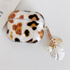 A clear silicone protective case with a leopard print design and pearl charm attached.