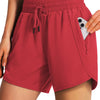 A woman wearing coral red quick-dry sports running shorts with an adjustable drawstring and side pockets.