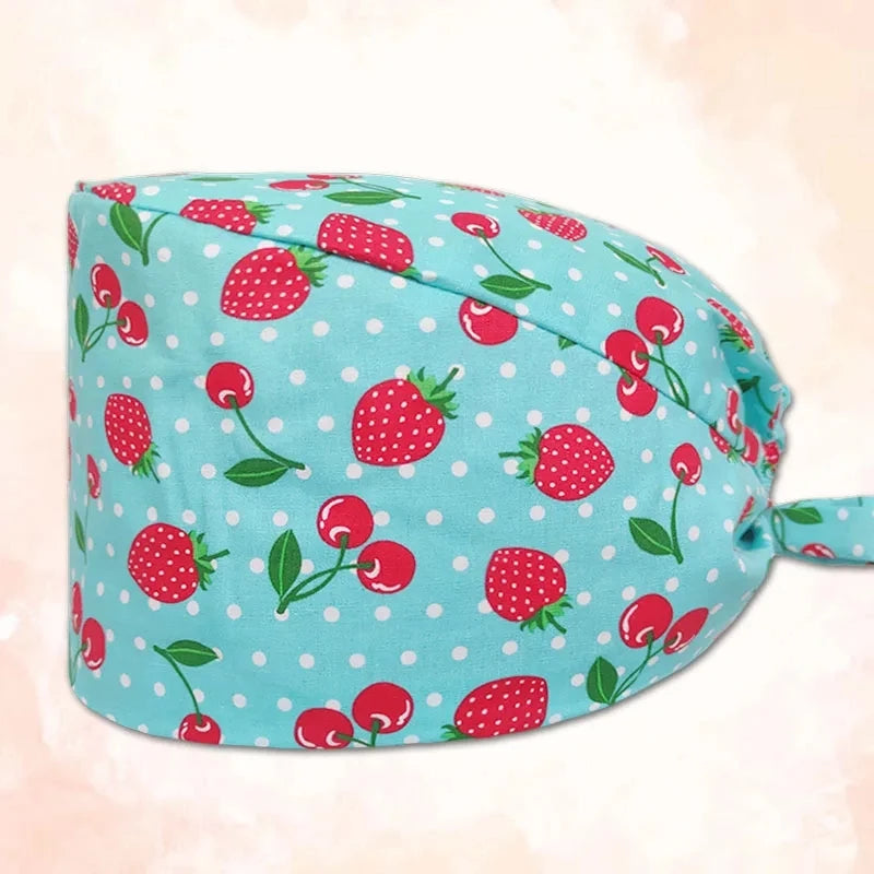 A light blue cotton surgical cap printed with red strawberries and green leaves.