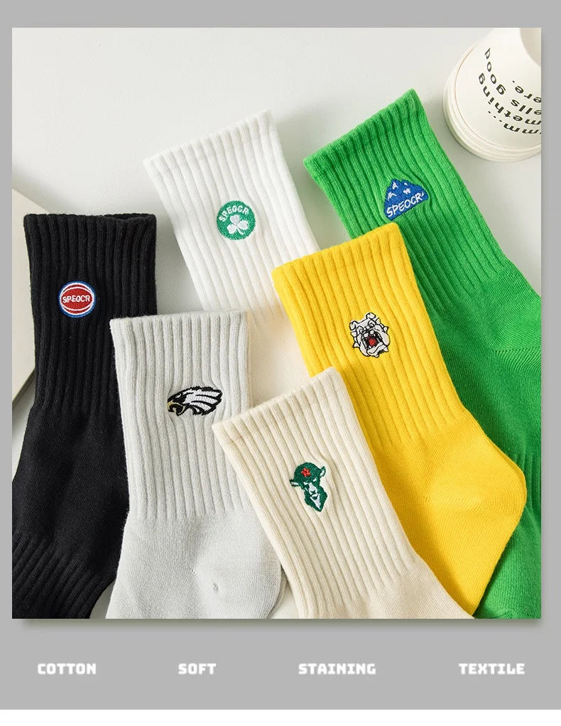 A collection of men's athletic crew socks in various colors including black, white, yellow, and green with embroidered logos.