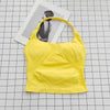 A bright yellow seamless sports camisole top laid on a grid background next to a photo.