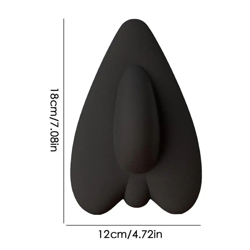 A black pelvic floor muscle trainer shaped like a leaf or teardrop, shown from above.