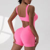 A model wearing a bright pink tie-dye sport jumpsuit from the back view.