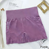 Shorts de fitness sin costuras para mujer color morado, extendidos sobre una superficie blanca.
