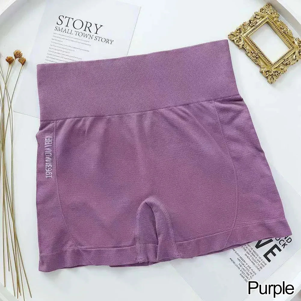 Shorts de fitness sin costuras para mujer color morado, extendidos sobre una superficie blanca.