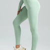A model wears seamless high-waist yoga leggings in mint green and a matching cropped top.