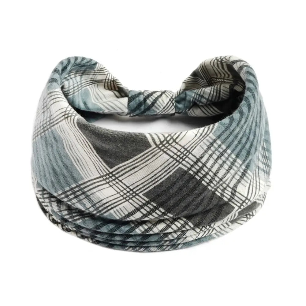Un bandeau pour les cheveux à large motif bohème dans des tons de gris et de blanc.