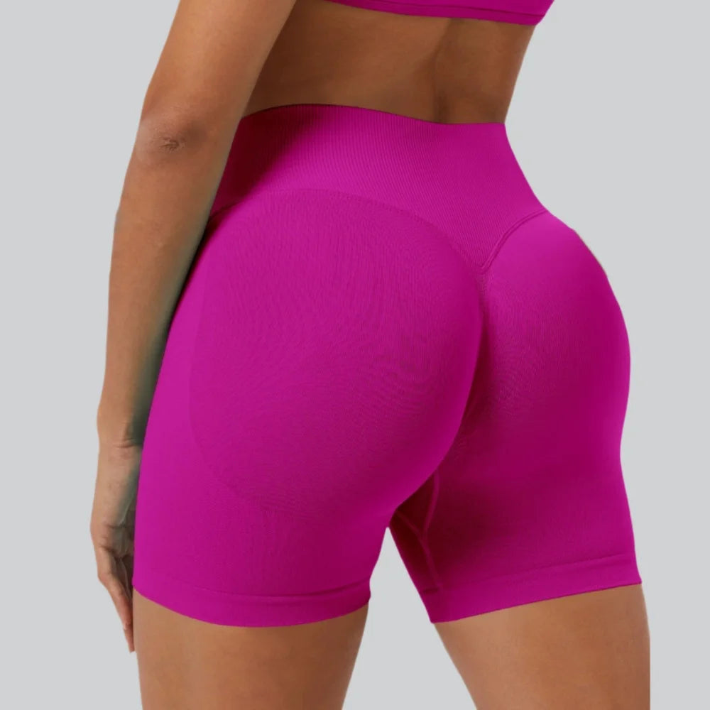 A close-up shot of a woman wearing bright magenta seamless high-waist yoga leggings.