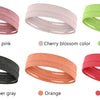 Eine Sammlung elastischer Sport-Headbänder in verschiedenen Farben, darunter Nude-Pink, Kirschblüte, Grün und Heathergrau.