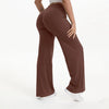 A person is modeling brown NCLAGEN SoftMotion straight leg yoga pants in a full-length shot.