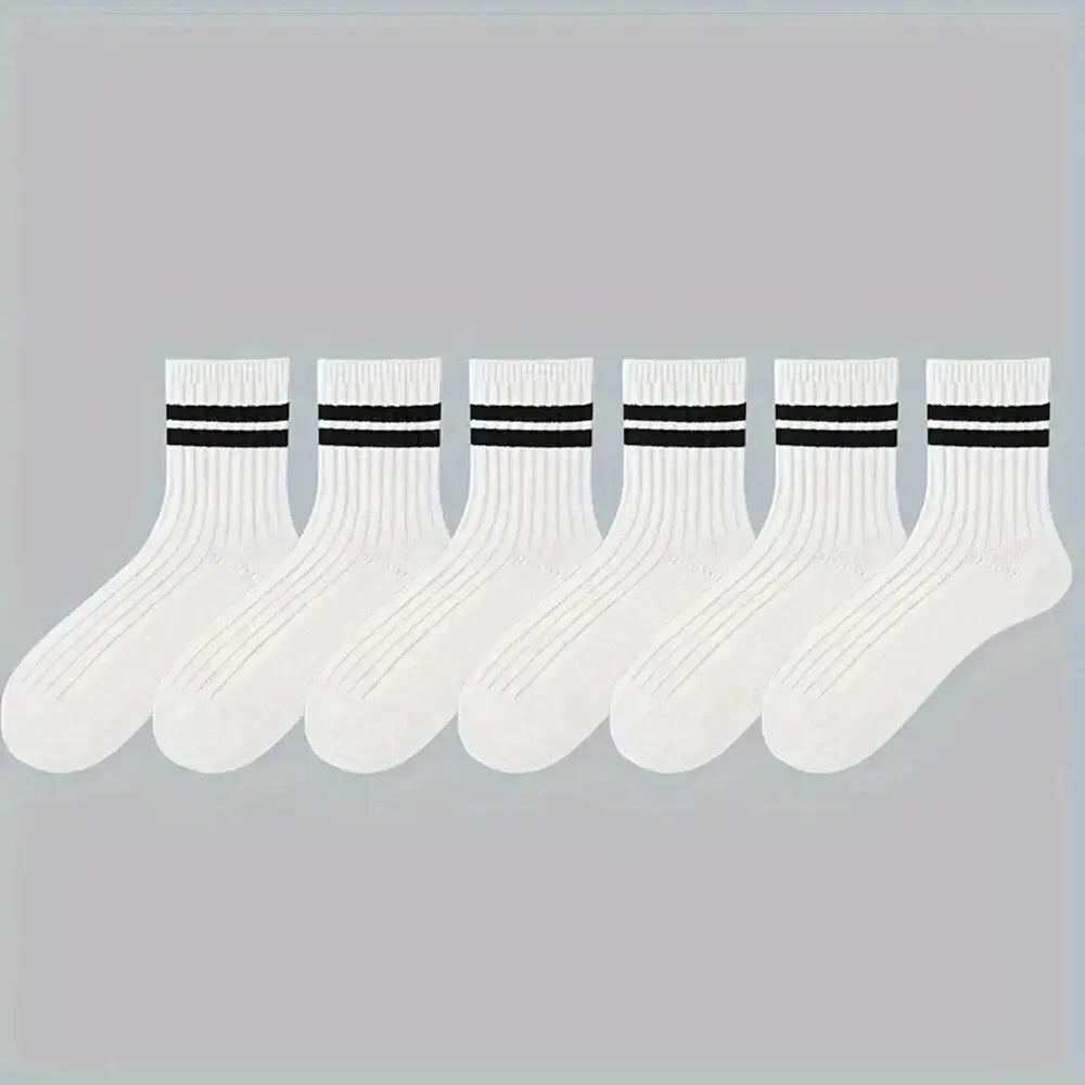 Eine Reihe weißer atmungsaktiver Socken mit schwarzen Streifen vor hellem grauem Hintergrund.