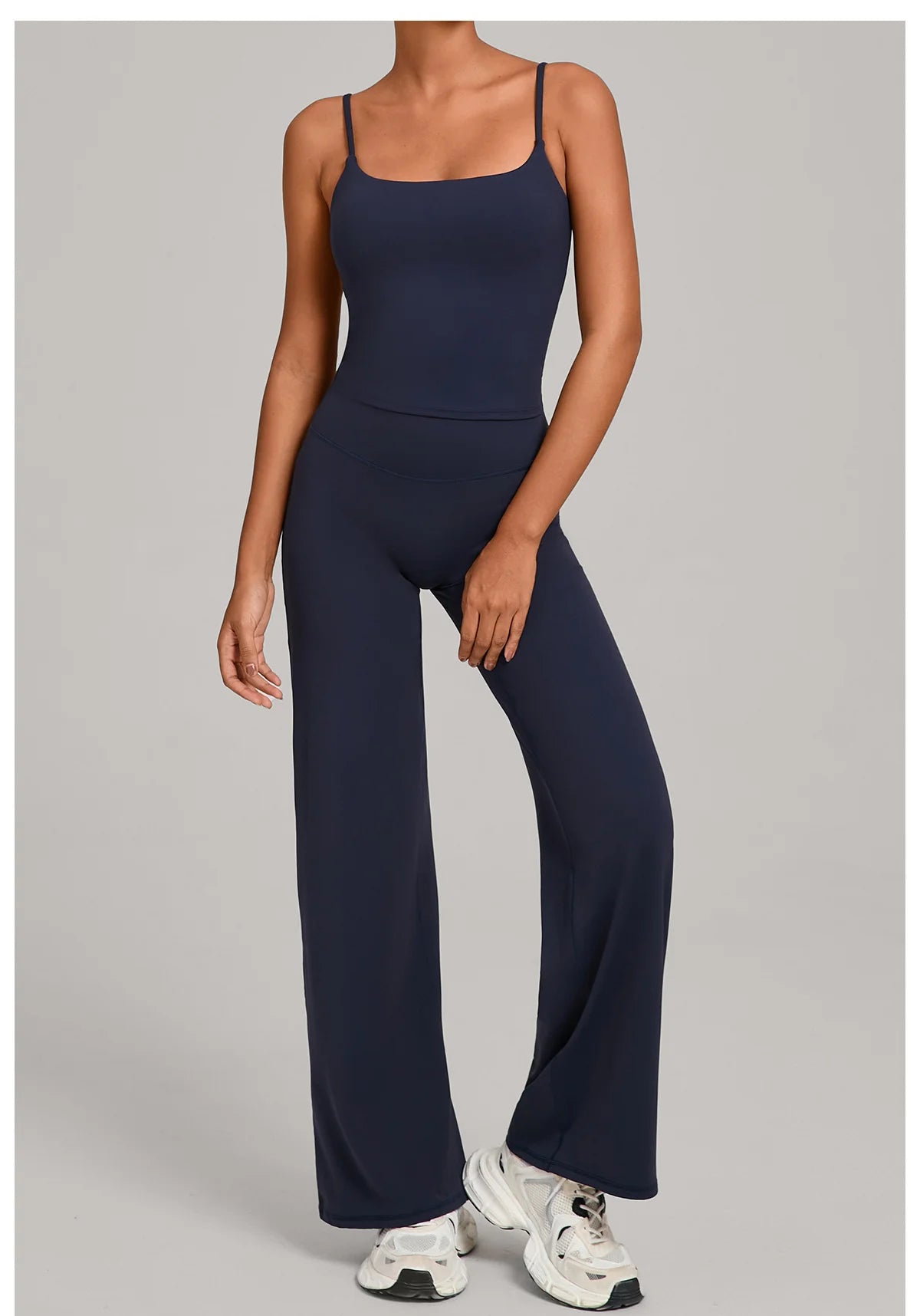 A woman wearing a navy blue high-waist yoga and fitness tracksuit set.