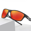 A pair of black sports sunglasses with bright orange-red polarized lenses resting on a white box.