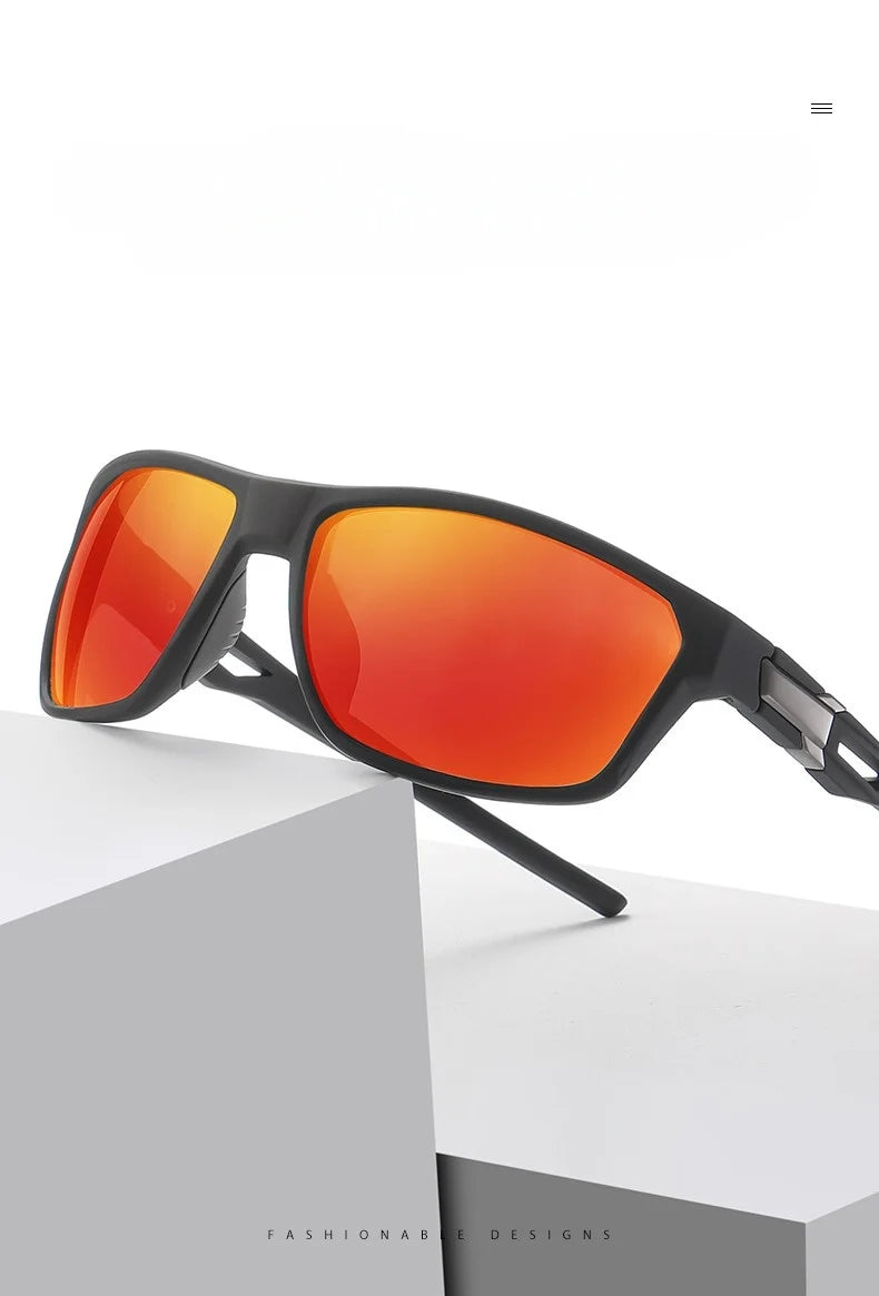 A pair of black sports sunglasses with bright orange-red polarized lenses resting on a white box.