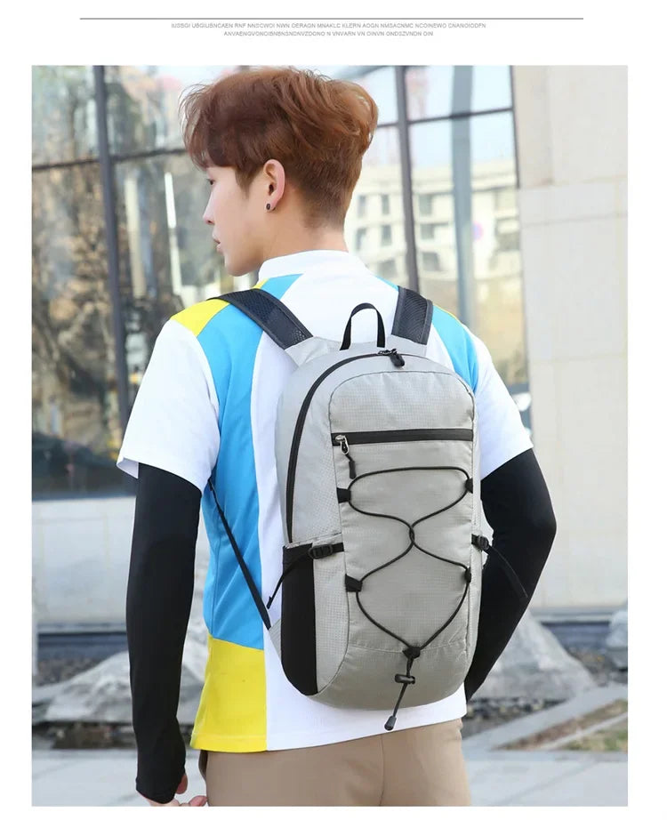 A person wearing a gray and black hiking backpack while standing outdoors.