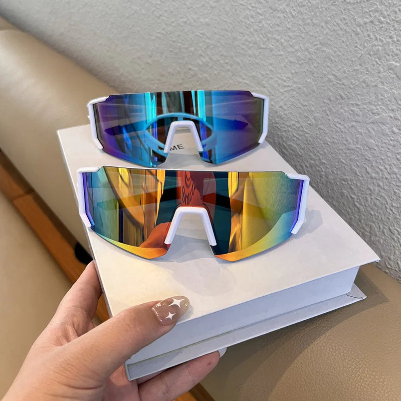 Pair of blue and orange UV400 cycling sunglasses resting on a white book.