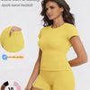 A woman models a yellow sports casual tracksuit top and shorts, highlighting dual side pockets.