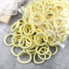 A pile of light yellow elastic hair bands is displayed on a gray surface.