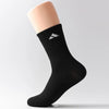 Schwarze Sportsocke mit weißem Adidas-Logo auf einer hellhäutigen Bein