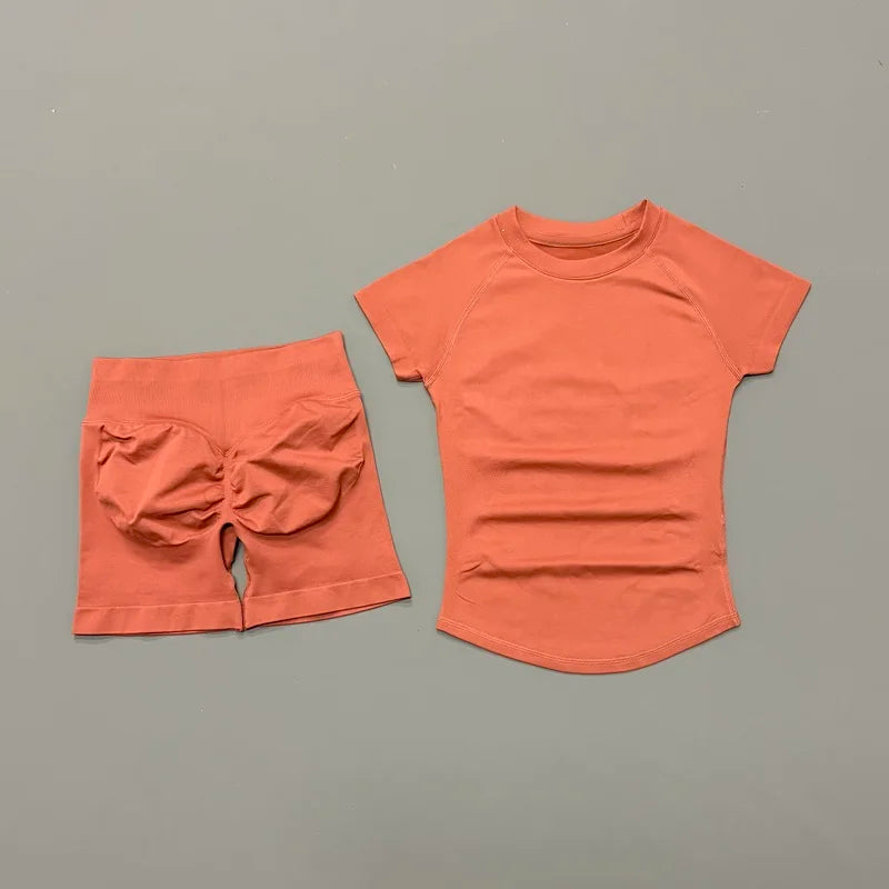 A terracotta orange seamless yoga set for women featuring a short sleeve top and matching shorts.