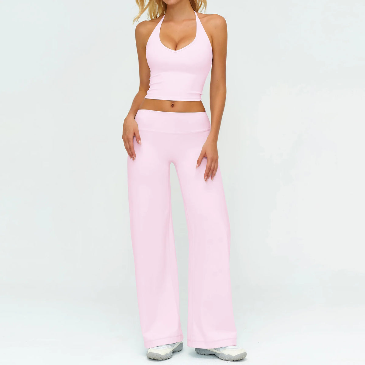 A woman wearing a pink women's premium fitness tracksuit top and matching pants.