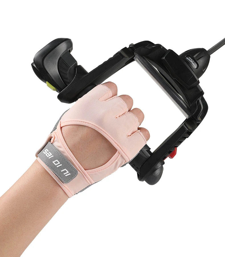Pink half finger sports gloves being worn on a wrist for weight lifting or exercise.