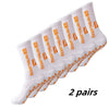 A pair of white non-slip grip socks with orange lettering for sports and activity