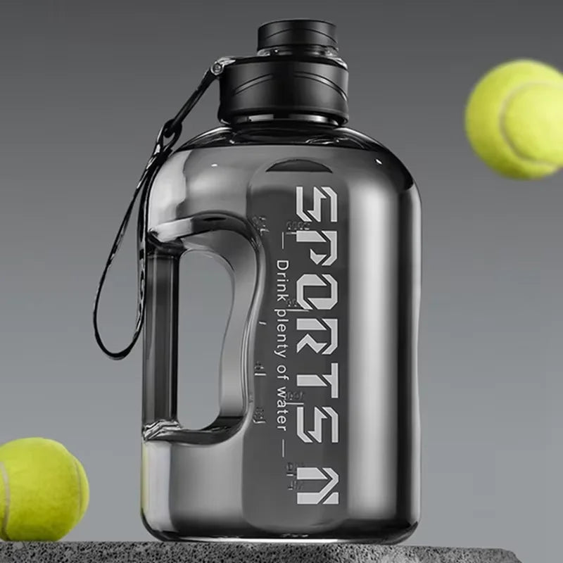Klare Sportflasche mit schwarzem Verschluss und Draht-Öse neben einem Tennisball.